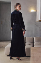 Load image into Gallery viewer, Image of the back of a woman wearing a black velvet full length robe with contrasting floral silk cuffs .
