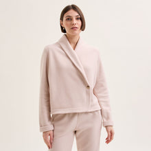 Load image into Gallery viewer, Sand. Soft fleece wrapover long sleeved bedjacket. It closes with a single Corozo button. The shawl collar and curved front detail add the final touches of style to this soft, light and cosy bedjacket. Made in Portugal. Available in Azur Blue Composition: 70% Polyester, 30% Viscose. Machine Washable.