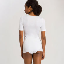 Load image into Gallery viewer, A woman wearing a white seamless cotton T-Shirt style top. It has a short sleeves and a round neck. The bottom of the shirt reaches the hips. Image of the back.