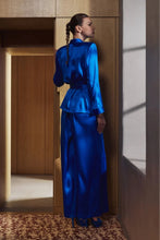Load image into Gallery viewer, The Bea pyjamas embody a bold and contemporary elegance. Made of 100% heavy-weight silk, it plays on the contrasts between structure and fluidity, for a silhouette that is both assertive and comfortable.
The pants, flexible and fluid, have subtle pleating to create a beautiful volume with lightness. The elasticated waist at the back, guaranteeing a perfect fit.
The tailored jacket, draws a clean line thanks to its thin collar and integrated shoulder pads. Its wide belt emphasises the waist and structures