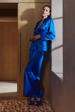 Load image into Gallery viewer, The Bea pyjamas embody a bold and contemporary elegance. Made of 100% heavy-weight silk, it plays on the contrasts between structure and fluidity, for a silhouette that is both assertive and comfortable.
The pants, flexible and fluid, have subtle pleating to create a beautiful volume with lightness. The elasticated waist at the back, guaranteeing a perfect fit.
The tailored jacket, draws a clean line thanks to its thin collar and integrated shoulder pads. Its wide belt emphasises the waist and structures