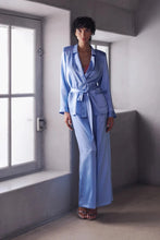 Load image into Gallery viewer, The Bea pyjamas embody a bold and contemporary elegance. Made of 100% heavy-weight silk, it plays on the contrasts between structure and fluidity, for a silhouette that is both assertive and comfortable.
The pants, flexible and fluid, have subtle pleating to create a beautiful volume with lightness. The elasticated waist at the back, guaranteeing a perfect fit.
The tailored jacket, draws a clean line thanks to its thin collar and integrated shoulder pads. Its wide belt emphasises the waist and structures