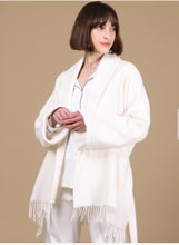 Load image into Gallery viewer, SALE Playful poncho style short wool robe. It has a wide shawl collar with fringe detail at the hem. Belted at the waist and with a large patch pocket to the front, this garment may be worn as lingerie or outerwear. Wherever it guarantees cosiness!
Fabric Content: 80% Wool, 20% Polyamide
95cm in length. Ivory.