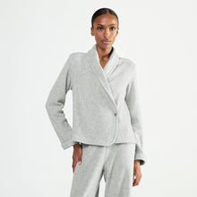 Load image into Gallery viewer, A woman wearing a light gray heathered shawl collar wrap bed jacket with a single button closure, photographed against a clean white studio background.