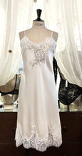 Load image into Gallery viewer, Butter/Ivory. Made in Italy, this is a beautiful long pure silk satin night/slip. There is stunning deep appliqué lace at the bust and hem. There are French seams throughout for softness. The fine spaghetti straps are adjustable for the perfect fit. This nightslip is cut on the bias and panelled giving lovely flare and movement. Perfect for bed or daywear. May be worn as underwear, nightwear or outerwear. Composition: 100% Silk Satin Italian Lace 100% polyamide Machine washable Length 82cm from nape.