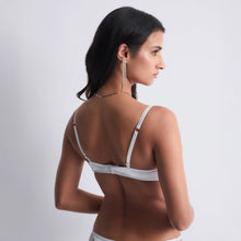 Load image into Gallery viewer, Giving the chest in a deep neckline accentuated by exclusive French embroidery inspired by the waves, the Satin Memories by Aubade underwired triangle bra offers a modern and resolutely sexy cut, all in transparent fabrics, with gold accent details. On the back, it is adorned with a very soft shiny satin for a feeling of comfort and lightness on a daily basis.
Image of the back.