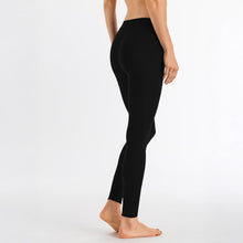 Load image into Gallery viewer, Image of the back of a woman wearing the black silk cashmere leggings. Showing that there is no seam going up the back of the bum.