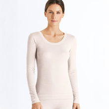 Load image into Gallery viewer, A woman wearing a vanilla long sleeve silk cashmere top. It has a deeper round neck (ideal for layering) with a soft trim. The sleeves are full length for ultimate cosiness.