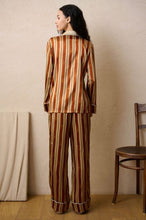 Load image into Gallery viewer, Heavy weight Stripe Silk Pyjamas made by Luuna Mine; an artisan design studio based in Shanghai. These are classic pure silk 'men's style' pyjamas They have contrasting blue piping on the cuff, ankle and jacket front. The collar is finished beautifully with a complementary gold silk. The pyjama print has a signature moon detail on the stripe. They are made 100% pure heavyweight Silk Satin. They have elasticated and a drawstring waist & French seams throughout.