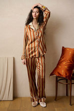 Load image into Gallery viewer, Heavy weight Stripe Silk Pyjamas made by Luuna Mine; an artisan design studio based in Shanghai. These are classic pure silk 'men's style' pyjamas They have contrasting blue piping on the cuff, ankle and jacket front. The collar is finished beautifully with a complementary gold silk. The pyjama print has a signature moon detail on the stripe. They are made 100% pure heavyweight Silk Satin. They have elasticated and a drawstring waist & French seams throughout.
