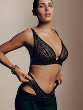 Load image into Gallery viewer, Woman wearing a black lace bralette against a beige background