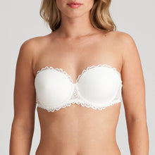 Load image into Gallery viewer, This is the attractive end of the strapless bra market. Beautifully smooth to the front but with a delicate lace trim on the cup to counterbalance any severity. The removable straps, if worn, are dainty and lace trimmed. This bra has the added bonus to create the halter style also. Fabric content: Polyamide: 53%, Polyester: 35%, Elastane: 12%. Ivory.