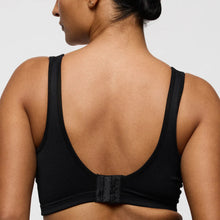 Load image into Gallery viewer, Black sports bra worn by a person on a plain background