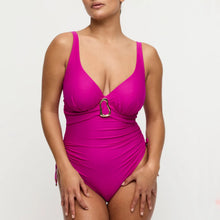 Load image into Gallery viewer, Woman wearing a bright pink swimsuit with a gold buckle on a light gray background