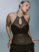 Load image into Gallery viewer, Woman wearing a black sheer top and skirt against a gray background