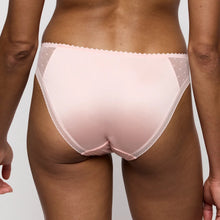 Load image into Gallery viewer, Light pink lace thong worn by a person on a neutral background