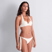 Load image into Gallery viewer, This stunning Simmer Stars formed plunge bikini top by Aubade showcases an elegant cream design enhanced by a double row of gleaming golden studs. The halter neck is a timeless classic that offers a flattering shape.
The lightly moulded cup on the top is underwired for additional support and light padding ensures a comfortable fuller fit.
This is a refined choice for those seeking both style and empowerment in their swimwear collection.