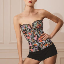 Load image into Gallery viewer, This is a beautiful corset made the French way. It has a square neckline at the front with pearl encrusted embellishment detail around its edges. The clever hidden boning and panelling that draws in the waist and supports the bust. The jolly Parrot pattern on a black ground continues around the back. where there is a centred zip. This is a stunning garment. It is perfect for outwear.