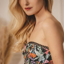 Load image into Gallery viewer, This is a beautiful corset made the French way. It has a square neckline at the front with pearl encrusted embellishment detail around its edges. The clever hidden boning and panelling draw in the waist and supports the bust. The jolly Parrot pattern on a black ground continues around the back. where there is a centred zip. This is a stunning garment. It is perfect for outwear.