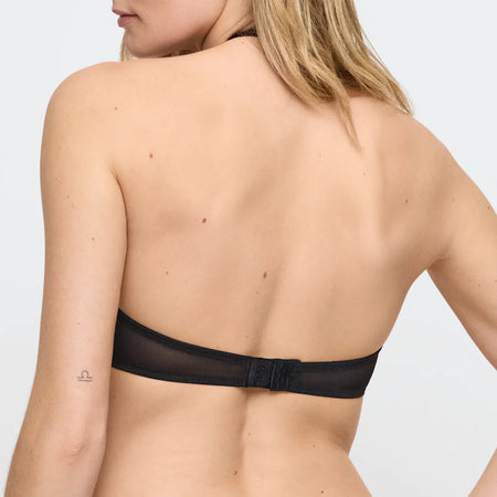 Black bra worn by a person on a light gray background