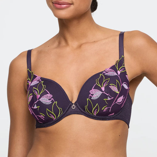 Woman wearing a floral-patterned bra on a plain background