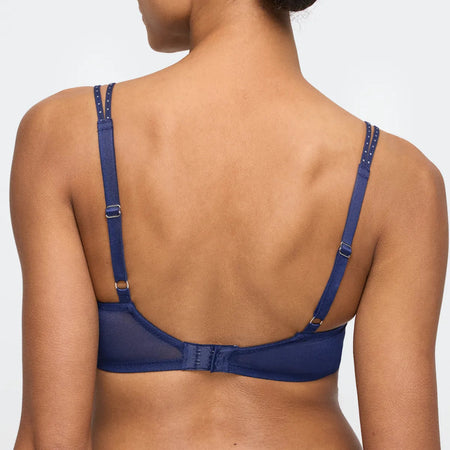 Blue bra worn by a model on a plain background