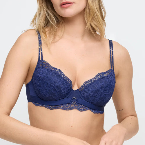 Blue lace bra worn by a model on a light gray background