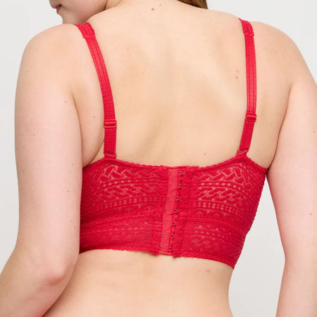 Red lace bralette worn by a person on a plain background