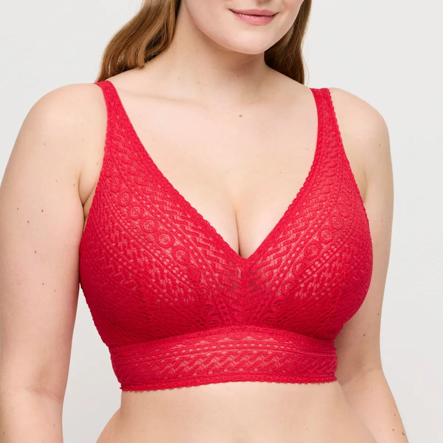 Red textured bralette worn by a model on a plain background