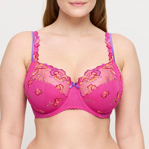 Pink bra with floral lace details worn by a model on a plain background