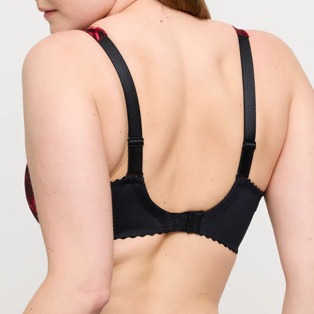 Black bra worn by a person on a plain background