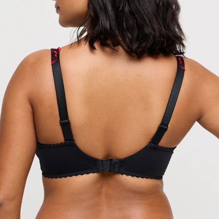 Black bra worn by a person on a plain background