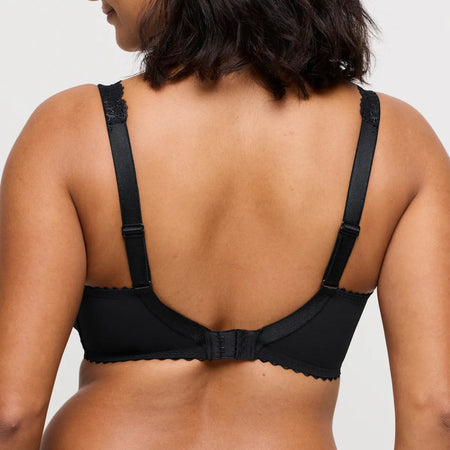 Black bra worn by a person on a plain background