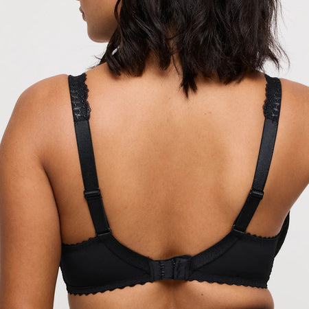 Black bra worn by a person on a plain background