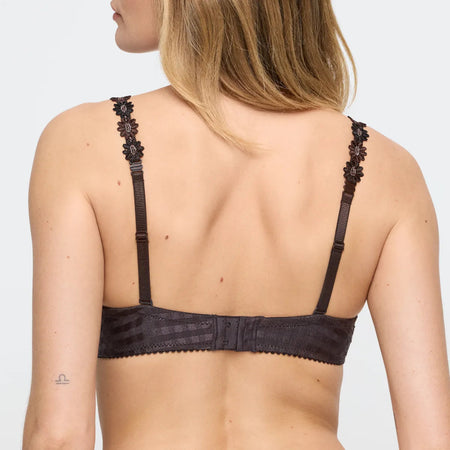 Black lace bra worn by a model on a plain background