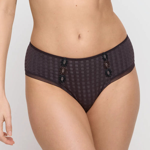 Dark patterned underwear worn by a person on a plain background