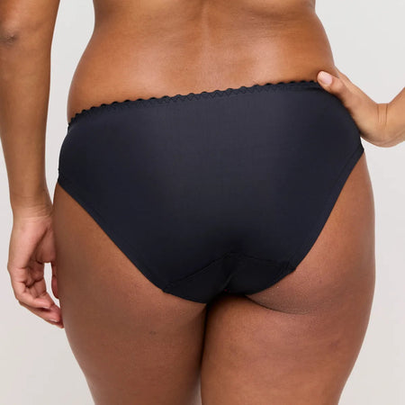 Person wearing black underwear on a plain background