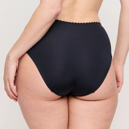 Person wearing black high-waisted underwear on a plain background