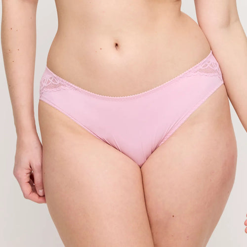 Person wearing a pink lace underwear set on a plain background