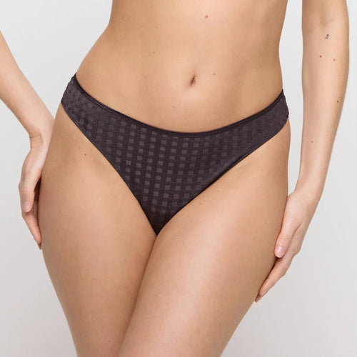 Person wearing a dark patterned underwear on a plain background