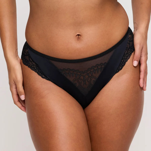 Black lace underwear worn by a person on a plain background
