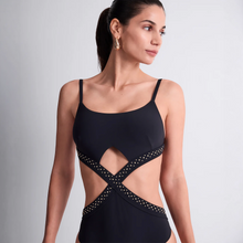 Load image into Gallery viewer, Woman wearing a black swimsuit with cut-out design on a gray background
X shape accentuates waist with 3 rows of gold stud design.
