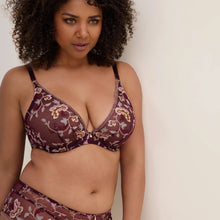 Load image into Gallery viewer, A woman modeling a sheer burgundy lace lingerie set with a floral pattern in gold and white, featuring underwire cups and matching bottoms, against a plain off-white background.
