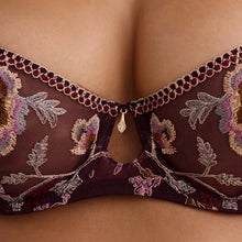 Load image into Gallery viewer, Close-up of a dark burgundy lace bra with floral embroidery and a small gold teardrop charm at the center, shown on a model.
