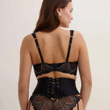 Load image into Gallery viewer, A woman shown from the back wearing a black lace lingerie set with gold-tone hardware, including a bralette, high-waisted corset-style waist trainer, and panty, against a plain light beige studio background.
