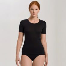Load image into Gallery viewer, A woman wearing a black seamless cotton T-Shirt style top. It has a short sleeves and a round neck. The bottom of the shirt reaches the hips. 
