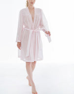 Short (102cm), Kimono Style short robe. Frilled detail on the hem edges and cuffs. The robe has belt and pocket. Made in Germany from the finest mousseline, this short, diaphanous robe is a 100% pure cotton. It offers the wearer perfect cover without heaviness. Celestine garments are addictive, so watch out. Once tried, there is no turning back! Celestine nightwear, dressing gowns and short robes drop from the shoulder, therefore one size fits all. Composition:  100% Pure Swiss Cotton Machine Washable