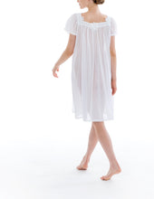 Load image into Gallery viewer, Short (98cm) short sleeve nightgown. Wide lace details on the square neckline. Narrow lace details on the short sleeve and hem edge. Flared skirt for ease of movement when sleeping. Made in Germany from the finest pure Swiss cotton, Celestine nightdresses are diaphanous, offering perfect sleep without heaviness. Celestine nightwear, dressing gowns and short robes drop from the shoulder, therefore one size fits all.  Fabric composition:  100% Pure Swiss Cotton. 100% Guipure Lace. Machine Washable.
