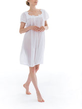 Load image into Gallery viewer, Short (98cm) short sleeve nightgown. Wide lace details on the square neckline. Narrow lace details on the short sleeve and hem edge. Flared skirt for ease of movement when sleeping. Made in Germany from the finest pure Swiss cotton, Celestine nightdresses are diaphanous, offering perfect sleep without heaviness. Celestine nightwear, dressing gowns and short robes drop from the shoulder, therefore one size fits all.  Fabric composition:  100% Pure Swiss Cotton. 100% Guipure Lace. Machine Washable.
