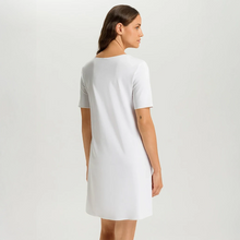 Load image into Gallery viewer, Embrace modern comfort with Hanro Cotton Silk Short-Sleeved Nightdress. This piece features a soft, mercerised cotton interlock construction, enhanced by subtle silk details. The short sleeves and ideal length of 90cm makes it perfect for a stylish and comfortable night's rest or relaxed lounging.
